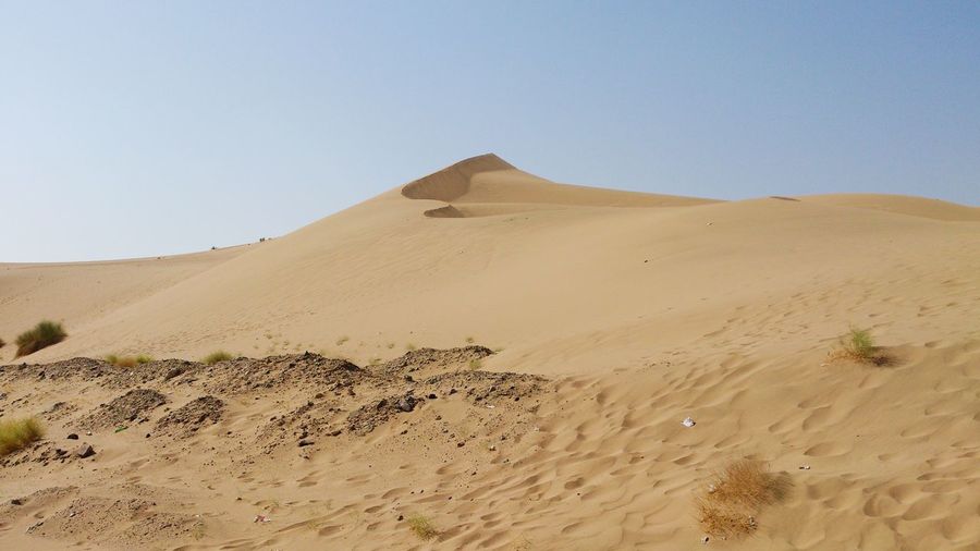 Scenic view of sand dune in desert against sky 