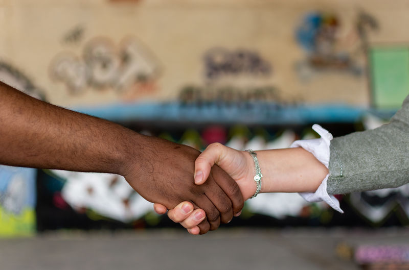 Cropped image of people shaking hands outdoors