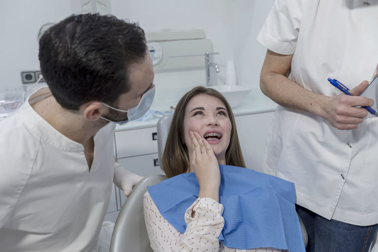 Dentists examining woman teeth in hospital