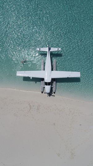 Aerial view of airplane on shore at beach