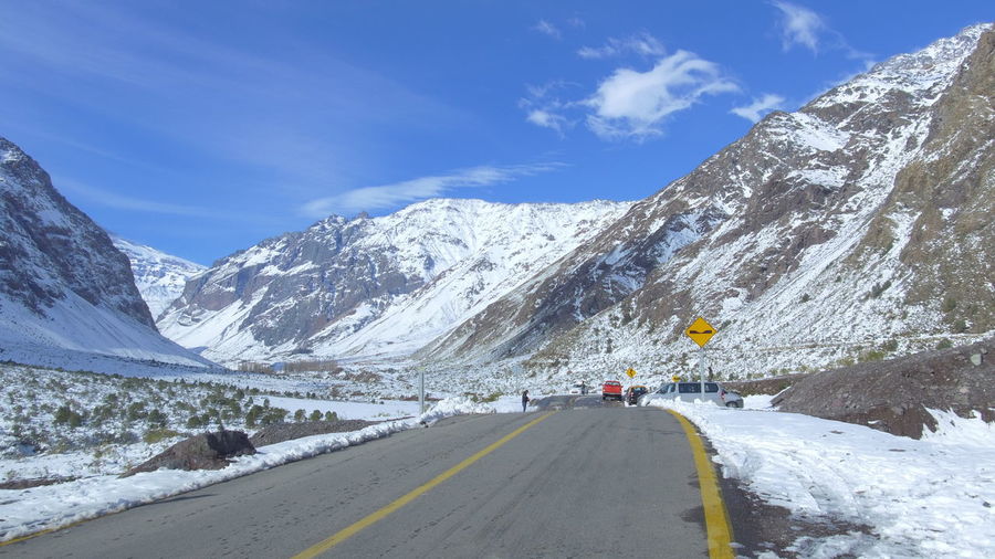 Road amidst snow covered mountains against sky