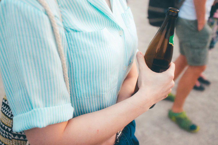 Midsection of woman holding beer