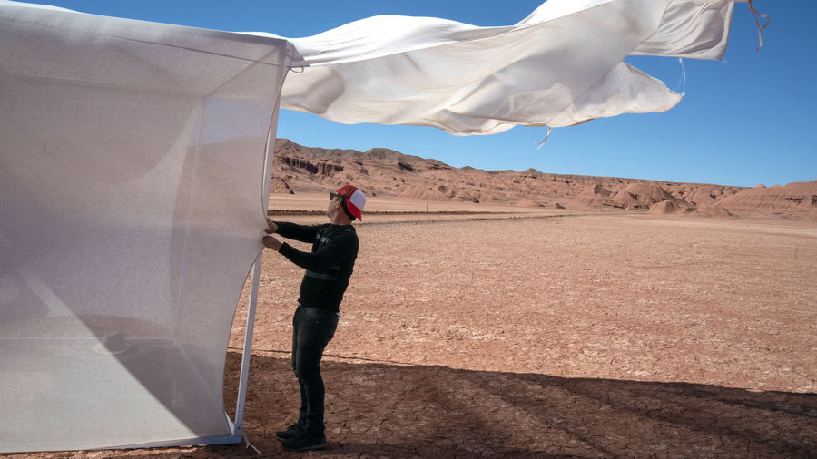 Side view of man standing by tent