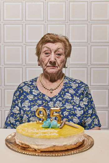 Portrait of old lady sitting on sofa at home