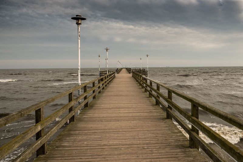 View of pier on calm sea against sky