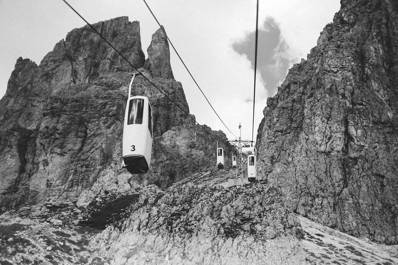 Overhead cable car in mountains against sky