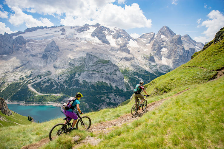 People riding bicycle on mountain against mountains