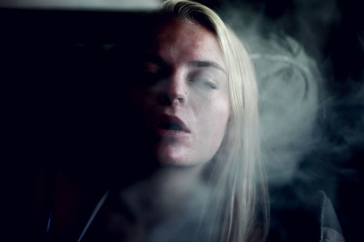 Young woman exhaling smoke