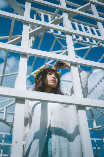 Woman standing by metallic built structure