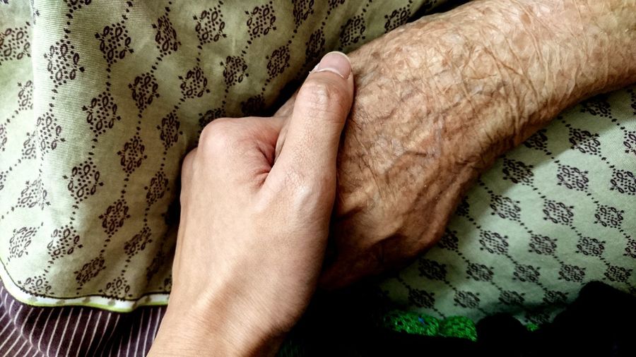 Cropped image of woman holding hands with mother