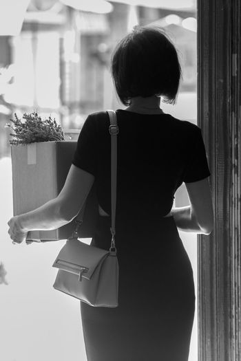 Rear view of woman carrying box