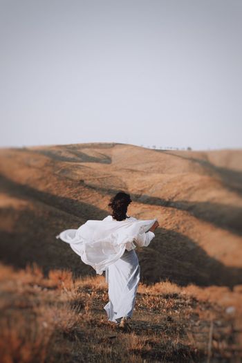 Rear view of woman with umbrella on land