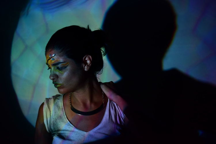 Light falling on woman looking down in darkroom