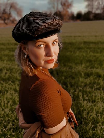 Portrait of beautiful young woman standing on field