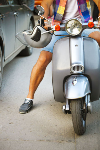 Low section of man riding motor scooter