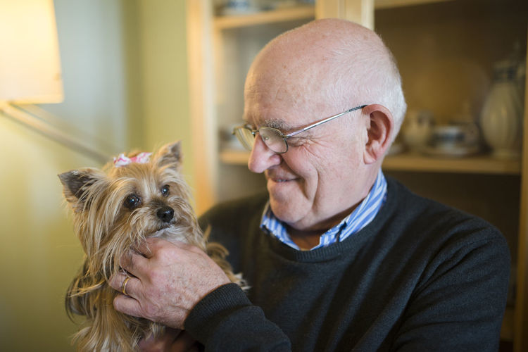 Senior man with his yorkshire terrier at home