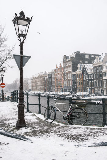 Street by canal in city during winter