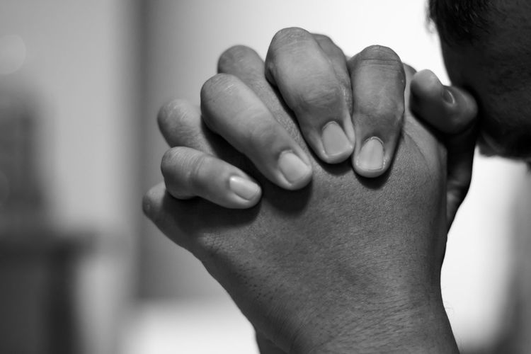 Depressed man close up hands is praying for hope and encouragement to continue living
