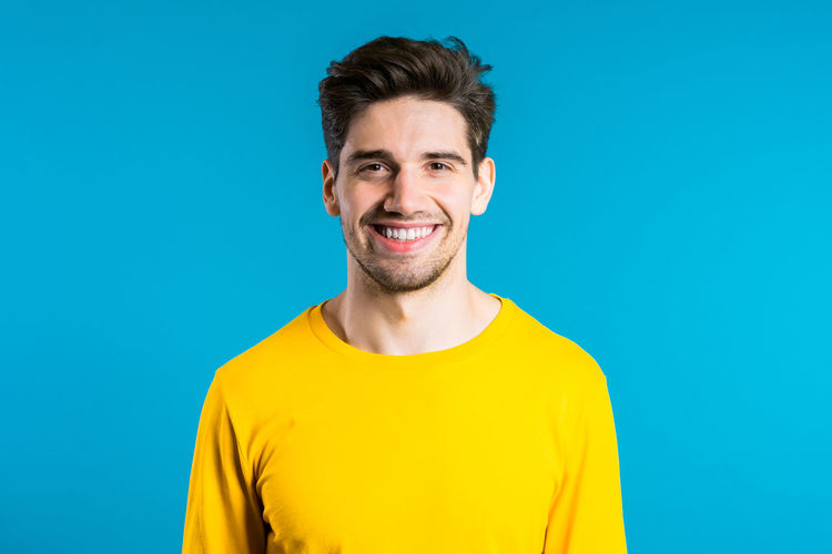 Portrait of smiling man against blue background