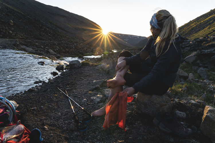 Hiker drying her feet after crossing glacial river
