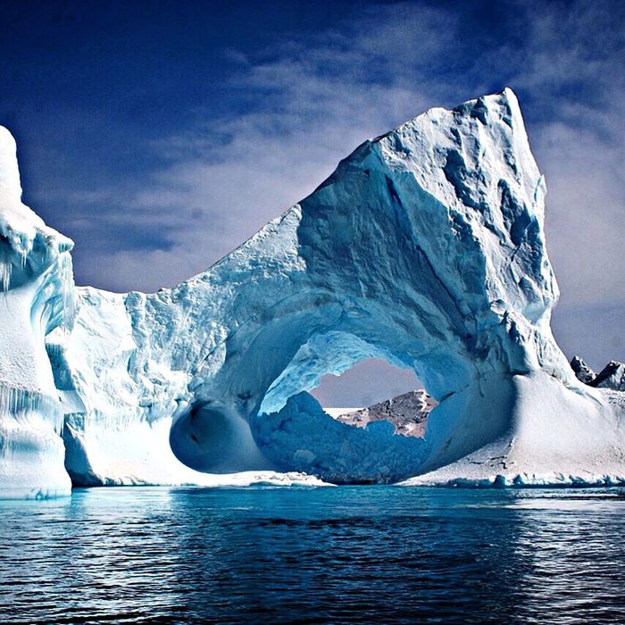 Iceberg by sea against sky