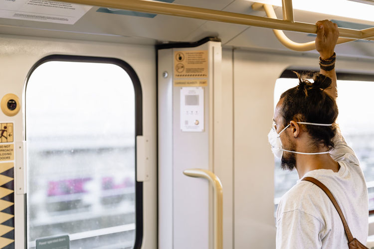 Man wearing mask standing in train