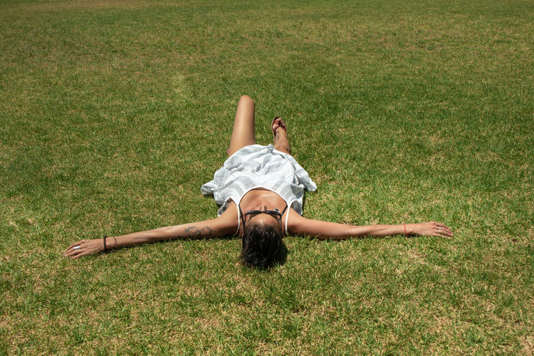 High angle view of woman lying on grass at park