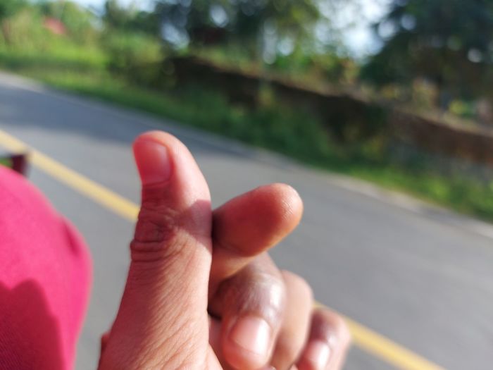 Close-up of hand holding blurred road