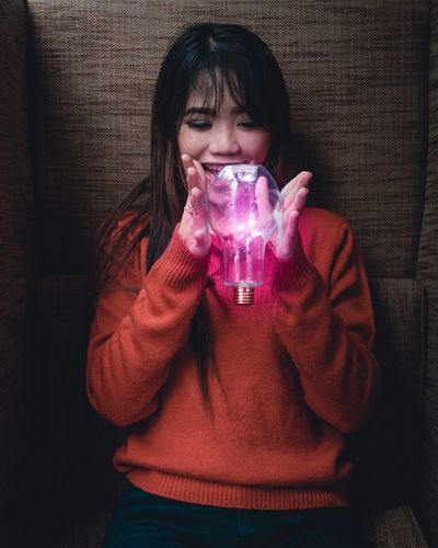 Young woman holding light bulb
