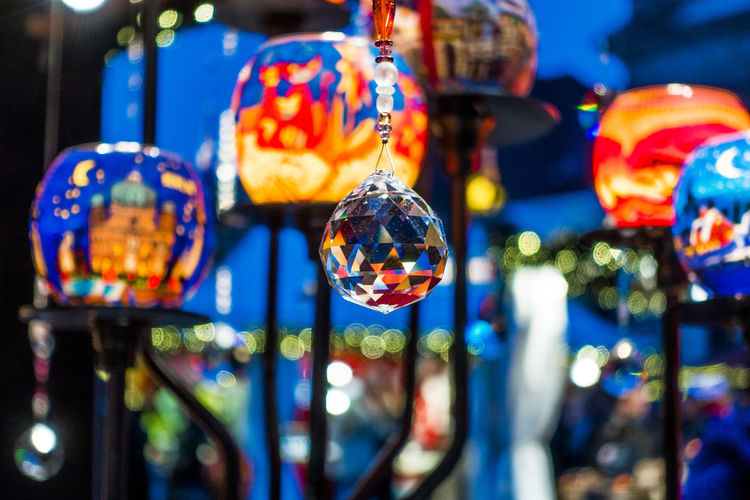 Close-up of christmas ornament hanging against illuminated lanterns