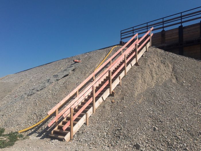 Low angle view of stairs against clear blue sky