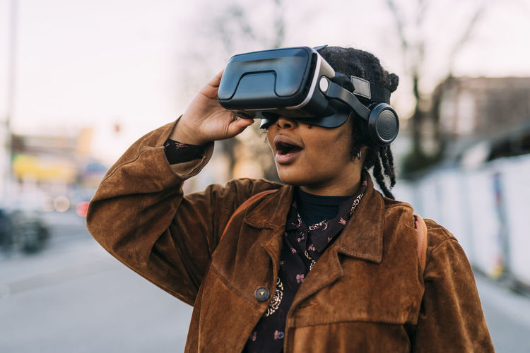 Young woman with mouth open using virtual reality headset