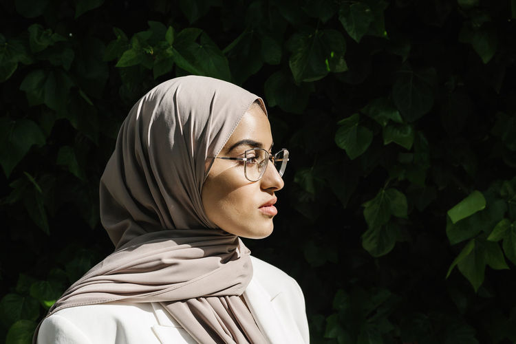 Young woman wearing eyeglasses looking away during sunny day