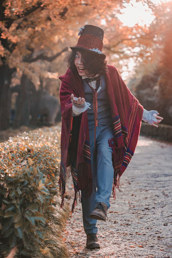 Woman with umbrella walking on street during autumn