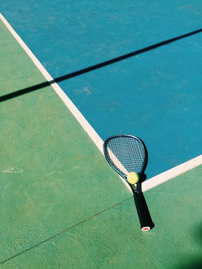 High angle view of tennis ball and racket on court