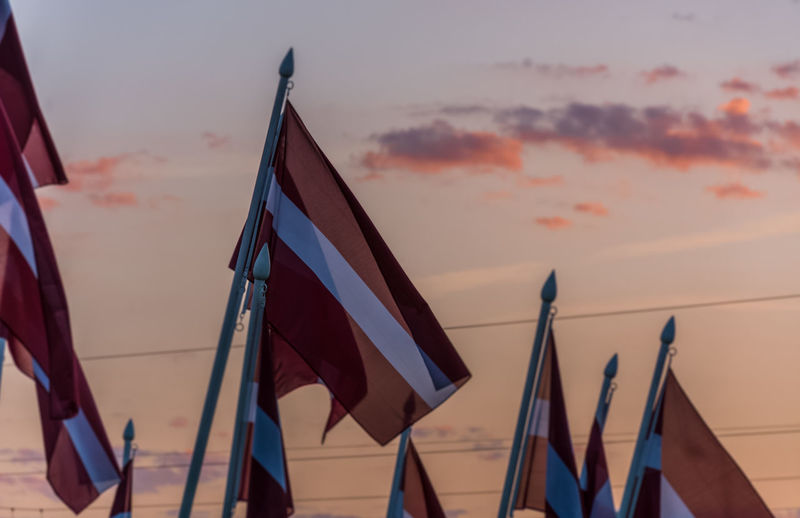 Low angle view of flags against sky during sunset