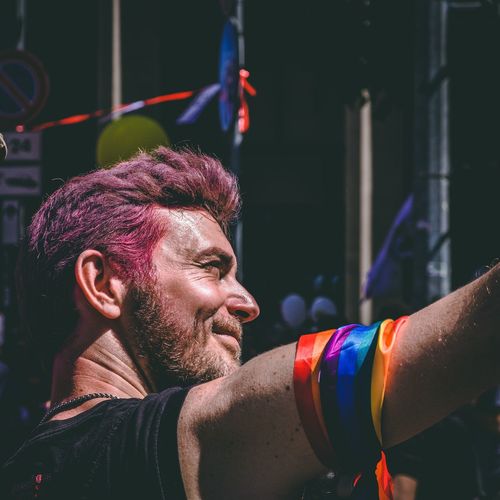 Low angle view of man wearing colorful ribbons during gay parade