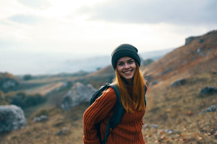 Portrait of smiling young woman standing on mountain