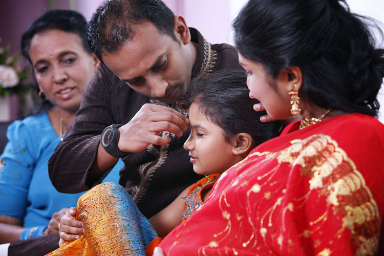 Family sitting on sofa at home
