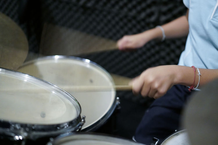 Midsection of person playing drums
