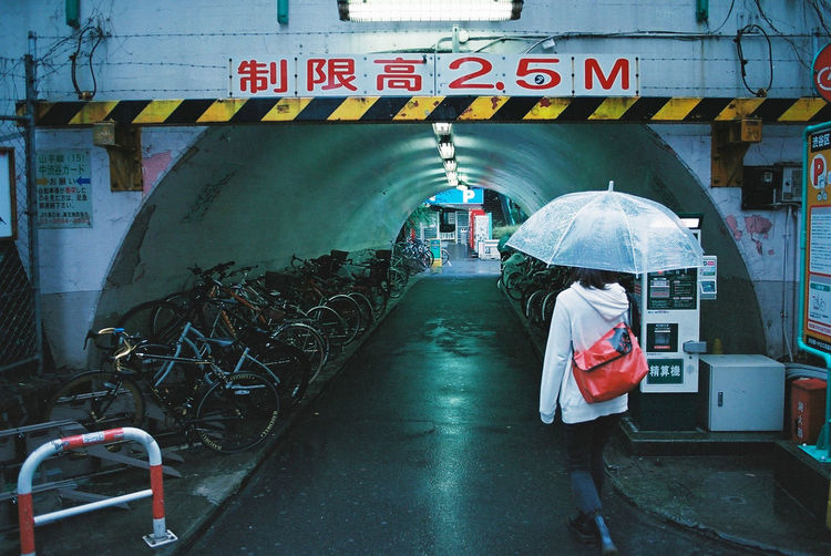 Rear view of woman standing on road