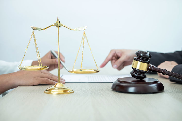 Cropped hands of lawyer pointing to documents for signing