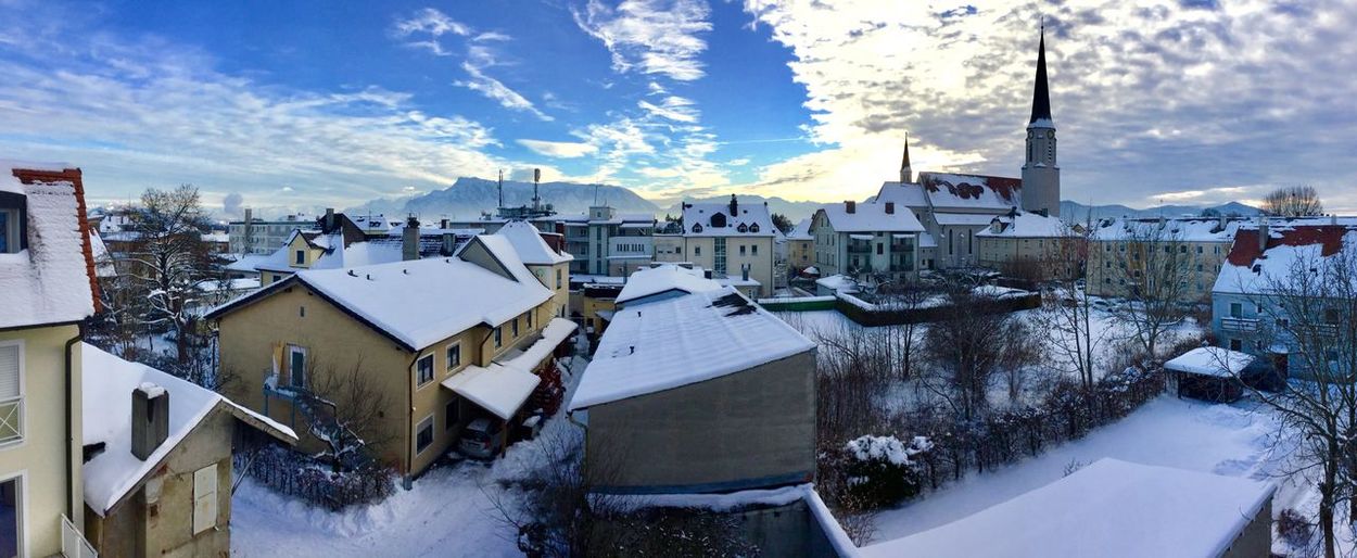 High angle view of townscape by snow covered houses against sky