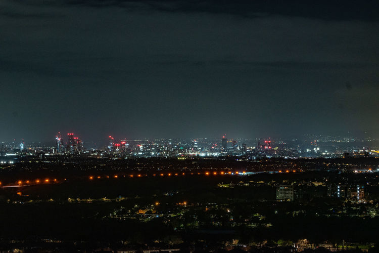 Illuminated cityscape against sky at night