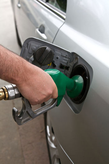 Close-up of man filling fuel in car