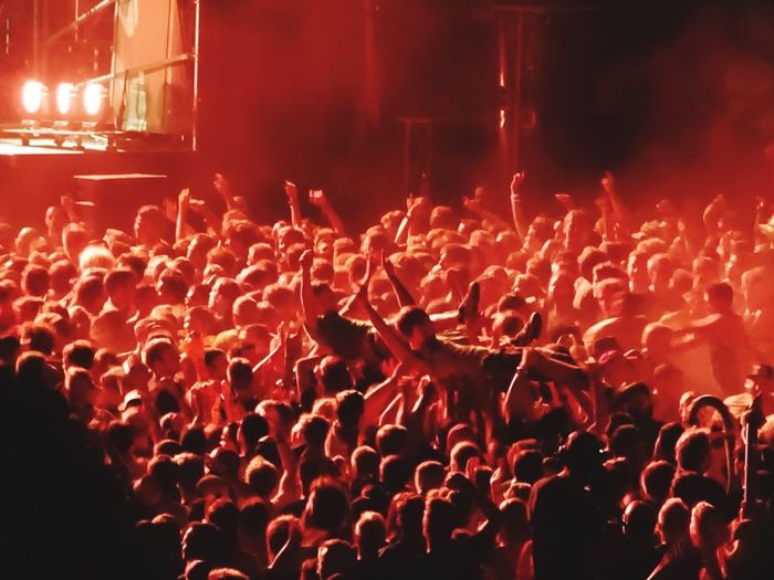Enthusiastic men crowd surfing at music festival
