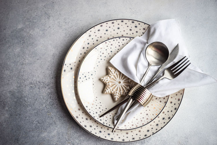 Festive place setting for holiday christmas dinner on concrete table