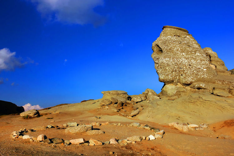 Sphinx of rock formations against blue sky
