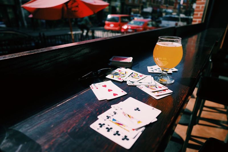 High angle view of cards with drinking glass on table at cafe