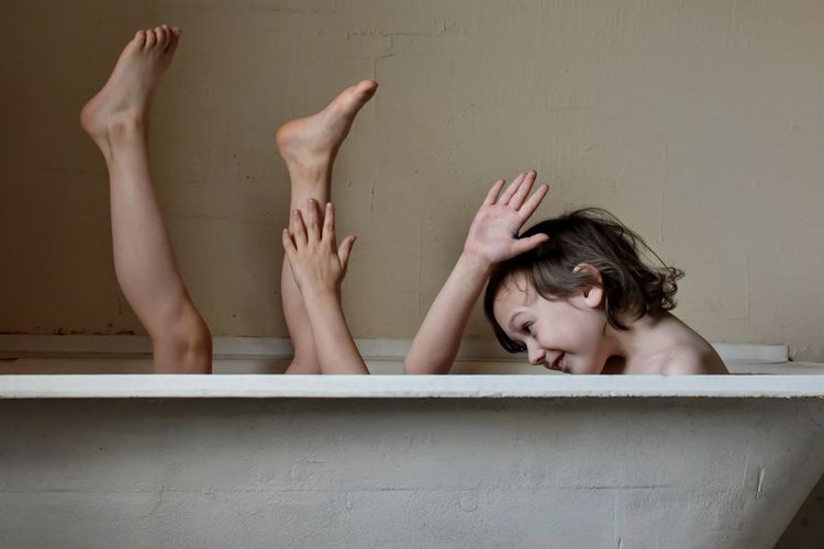 Playful brothers in bathtub at home